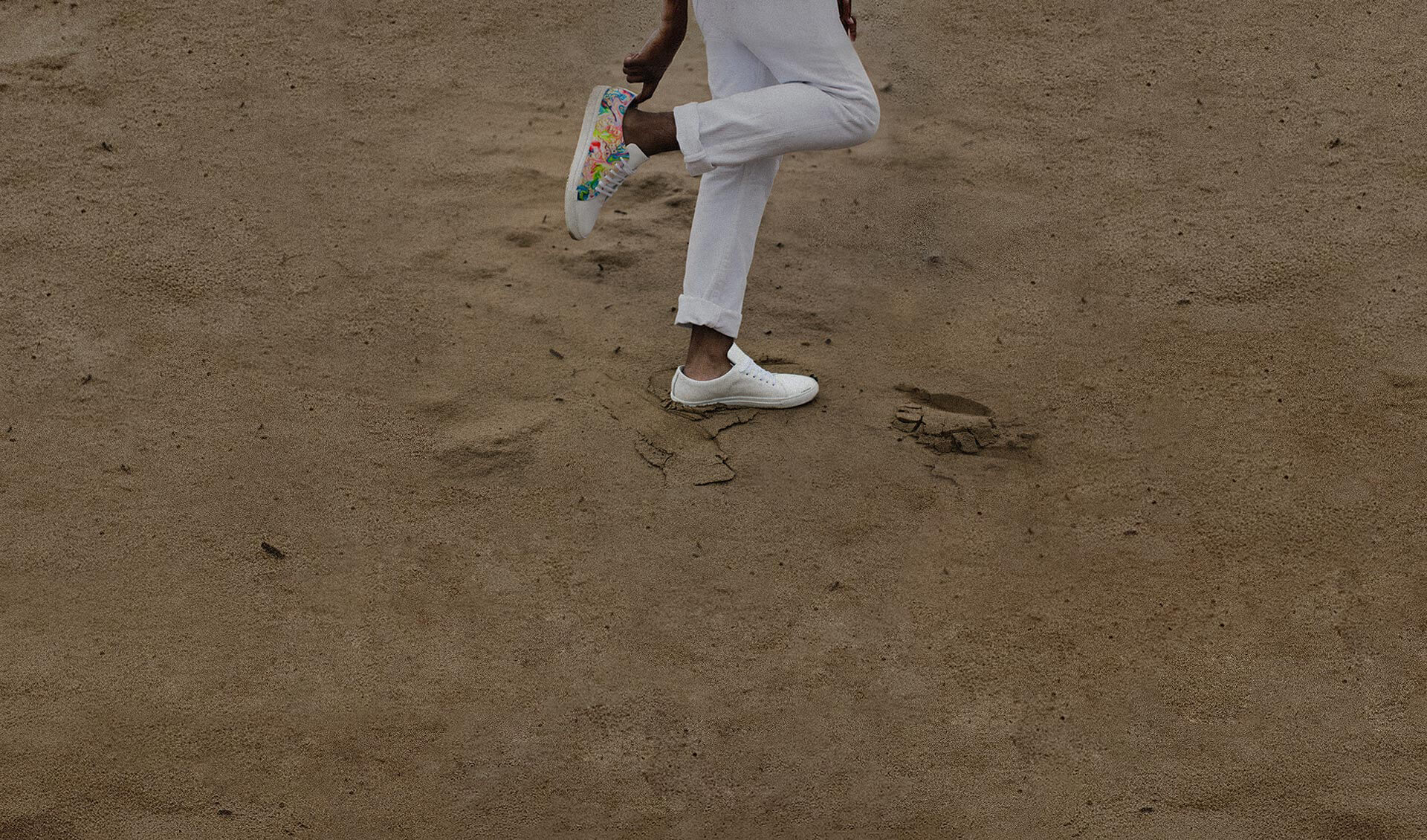 Foto de uma pessoa que está usando tênis segurando um dos pés